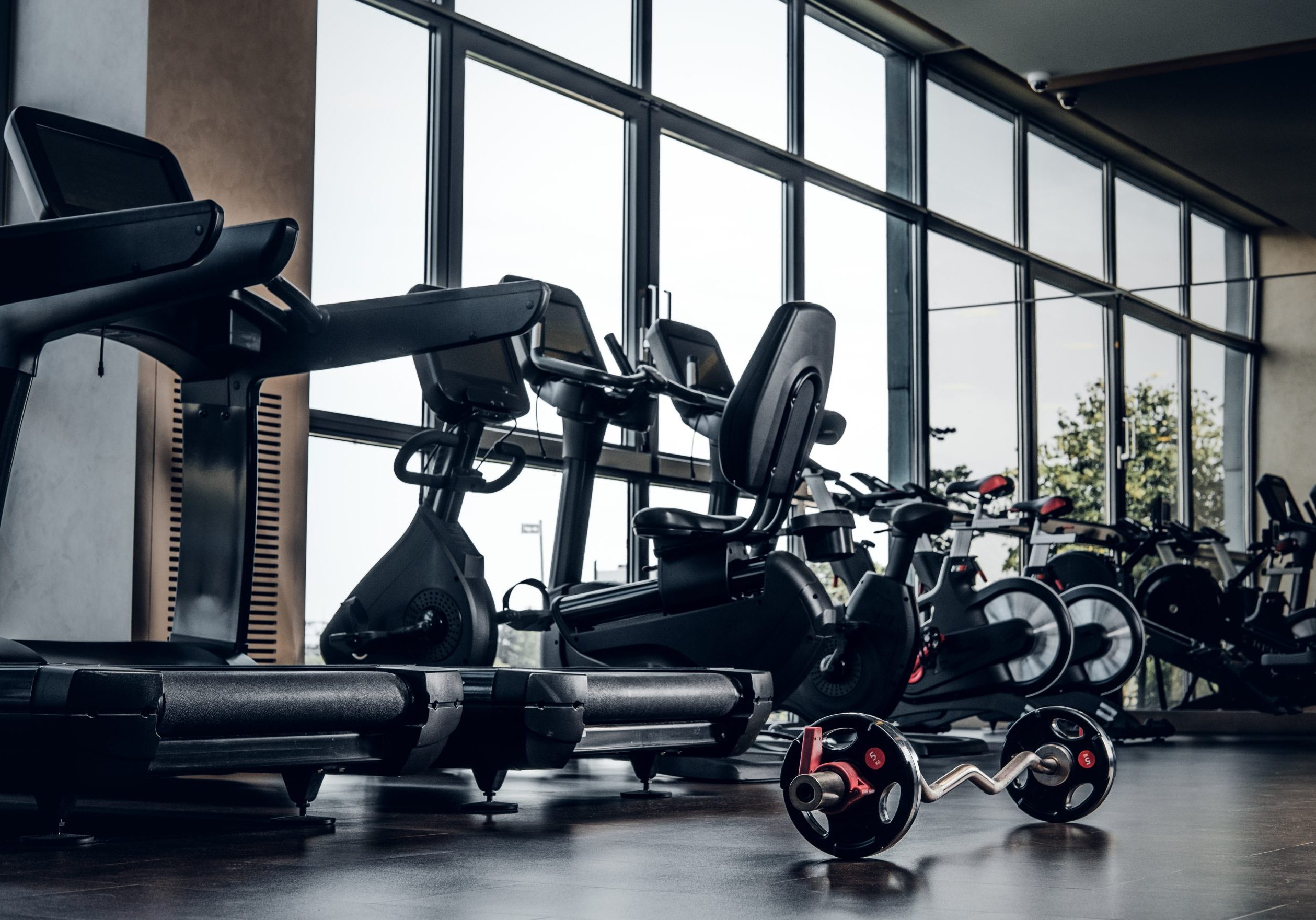 New empty gym club with different type of training apparatuses and big window. New empty gym club with different type of training apparatuses and big window.